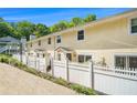 Street view of cozy townhomes featuring yellow siding and quaint, fenced front yards with lush landscaping at 2716 Suwanee Se Way, Marietta, GA 30067