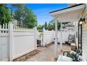 Inviting entrance with a white picket fence and a cozy seating area on the covered patio at 2716 Suwanee Se Way, Marietta, GA 30067