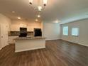Modern kitchen featuring white cabinets, granite countertops, stainless steel appliances, and an island overlooking the living area at 2285 Crossrail Dr, Atlanta, GA 30349