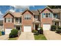 Attractive townhome featuring a brick front, attached garage, and well-maintained landscaping enhancing its curb appeal at 5485 Sierra Trl, Atlanta, GA 30349
