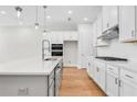 Spacious kitchen with island, white cabinets, stainless appliances, and hardwood flooring at 2556 Silver Star Ne Dr, Marietta, GA 30066