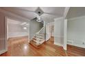 Bright foyer featuring gleaming hardwood floors, elegant staircase, and an open doorway to the living area at 2976 Matthew Ln, Lawrenceville, GA 30044