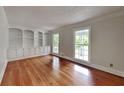 Cozy living room with hardwood floors, built-in bookshelves and cabinets, and natural light at 2976 Matthew Ln, Lawrenceville, GA 30044