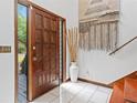 Elegant entryway with a wooden door, striking tapestry and white tile flooring that offers a luxurious welcome at 4514 Creekwood Nw Cir, Kennesaw, GA 30152