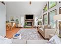 Sunlit living room featuring a stone fireplace, hardwood floors and expansive windows providing picturesque outdoor views at 4514 Creekwood Nw Cir, Kennesaw, GA 30152