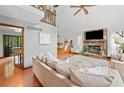 Bright living room with stone fireplace, hardwood floors and large windows showcasing lush outdoor views at 4514 Creekwood Nw Cir, Kennesaw, GA 30152