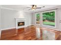 Inviting living room features a cozy fireplace, large windows, and gleaming hardwood floors at 2437 Camden Lake Nw Vw, Acworth, GA 30101