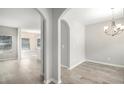 Open-concept dining room with an elegant chandelier, archway access, and light wood floors at 458 Ajo Way, Dallas, GA 30157
