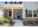 Inviting front entrance featuring stone accents, a dark-colored front door, and decorative landscaping at 458 Ajo Way, Dallas, GA 30157