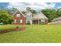Beautiful two story brick home with a green lawn, lovely landscaping, and shuttered windows at 3641 Willow Club Dr, Loganville, GA 30052