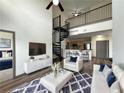 Inviting living room features a spiral staircase, sleek furniture, and an open layout to the kitchen at 390 17Th Nw St # 6001, Atlanta, GA 30363