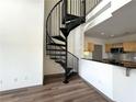 Modern spiral staircase leading to the second floor near the kitchen with stainless steel appliances at 390 17Th Nw St # 6001, Atlanta, GA 30363