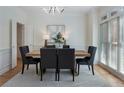 Elegant dining room features modern lighting, beautiful hardwood floors, and a large window for natural light at 1575 Wynridge Pointe, Alpharetta, GA 30005