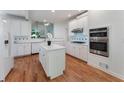 Modern kitchen boasts white cabinetry, an island, and stainless steel appliances offering a clean and functional space at 1575 Wynridge Pointe, Alpharetta, GA 30005