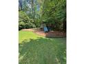 Community playground featuring swings, slides, and play structures for Gathering enjoyment amid lush landscaping at 4774 Olde Village Ln, Atlanta, GA 30338