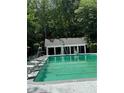 Tranquil community swimming pool with chairs and lifeguard station surrounded by lush greenery at 4774 Olde Village Ln, Atlanta, GA 30338
