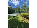 Well-maintained community tennis courts with players in action, surrounded by landscaped greenery and shade at 4774 Olde Village Ln, Atlanta, GA 30338