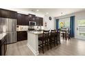 Modern kitchen featuring stainless steel appliances, granite countertops, and a breakfast bar at 6235 Crescent Landing Dr, Cumming, GA 30028