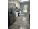 Modern kitchen with stainless steel appliances, gray walls, updated lighting, and wood-look flooring at 324 Cynthia Ct, Jonesboro, GA 30238