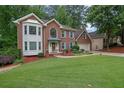 Lovely brick home with a manicured lawn, flower beds, and an attached two-car garage at 4373 Mikandy Nw Dr, Kennesaw, GA 30144
