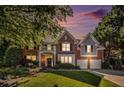 Beautiful two-story brick home featuring an attached two-car garage and a well-manicured lawn at dusk at 5004 Lake Mist Se Dr, Mableton, GA 30126