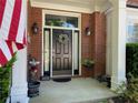 Inviting front entrance with a wreath, classic brick facade, and elegant outdoor lighting at 5004 Lake Mist Se Dr, Smyrna, GA 30126