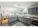 Open kitchen with gray cabinets and counter seating, seamlessly flowing into the dining area at 173 Avalon Way, Riverdale, GA 30274
