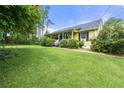 Spacious front yard with a yellow house, lovely porch, and beautiful green trees at 4720 Bill Cheek Rd, Auburn, GA 30011