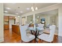 Cozy dining area with hardwood floors, chandelier, and views into the kitchen and living room, perfect for meals at 6805 Bransford Dr, Cumming, GA 30040