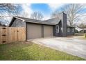 Side view of the home showcasing the two-car garage, driveway, and partial fence at 170 Gilreath Nw Rd, Cartersville, GA 30121