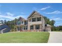 Inviting two-story home with a mix of brick and siding, complemented by a green lawn at 68 Homesite Cooper W Cv, Fayetteville, GA 30214