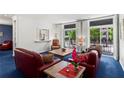Bright living room with plush blue carpeting, red sofas, and large windows with shutter-style shades at 1421 Peachtree Ne St # 214, Atlanta, GA 30309