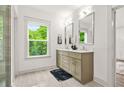 Bright bathroom with double vanity, ample natural light, and a view of the lush, green outdoors at 2318 Polar Rock Terrace, Atlanta, GA 30315