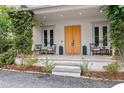 Cozy front porch with double doors, charming seating, and beautiful landscape at 110 3Rd St, Fayetteville, GA 30214