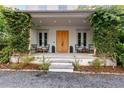 Welcoming front porch adorned with climbing plants, comfortable seating, and a stylish entrance with a natural wood door at 110 3Rd St, Fayetteville, GA 30214