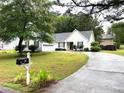 Landscaped front yard of single-story home with white siding, black shutters, and a driveway at 1255 Summit Point Ln, Snellville, GA 30078