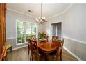 Elegant dining room featuring a wooden table, chandelier, and a large window at 2759 Beddington Way, Suwanee, GA 30024