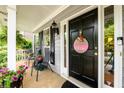 Welcoming front porch with seating area and decorative front door with glass sidelights at 2759 Beddington Way, Suwanee, GA 30024