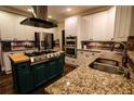 Gourmet kitchen with stainless steel appliances, center island with gas cooktop, granite countertops, and white cabinetry at 308 Forkwood Trl, Woodstock, GA 30189