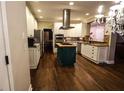 Spacious kitchen featuring stainless steel appliances, gas cooktop on island, granite countertops, and sleek hardwood floors at 308 Forkwood Trl, Woodstock, GA 30189