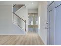 Inviting entryway featuring wood floors, a staircase with iron balusters, and an open view to the living area at 327 Tulip Dr, Covington, GA 30016