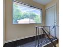 Hallway showing stairs with metal railings and a view through a window; unit entrance door at 100 Biscayne Nw Dr # D7, Atlanta, GA 30309