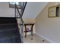 Hallway with black carpet stairs, a small decorative table with tiled floors, and neutral colored walls at 100 Biscayne Nw Dr # D7, Atlanta, GA 30309