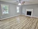 Spacious living room with two windows, a fireplace with white mantel, and light wood grain vinyl plank flooring at 3045 Revere Cir, Snellville, GA 30039