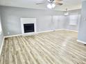 Bright, open living room with gray walls, white trim, a fireplace, ceiling fan, and vinyl plank flooring at 3045 Revere Cir, Snellville, GA 30039
