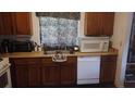 Galley kitchen with wooden cabinets, stainless steel sink, and a white dishwasher at 335 Chase Woods Cir, Jonesboro, GA 30236