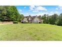 Beautiful front exterior view of the home with a manicured lawn and mature trees at 11440 Azalea Trl, Hampton, GA 30228