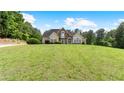 Beautiful front exterior view of the home with a manicured lawn and mature trees at 11440 Azalea Trl, Hampton, GA 30228