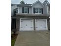Two car garage of a two-story home with grey siding and black shutters at 1155 Park Center Cir, Austell, GA 30168