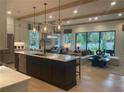 Open floor plan with large kitchen island, integrated dining area, and a spacious living room with exposed beams at 210 Mooney Rd, Woodstock, GA 30188